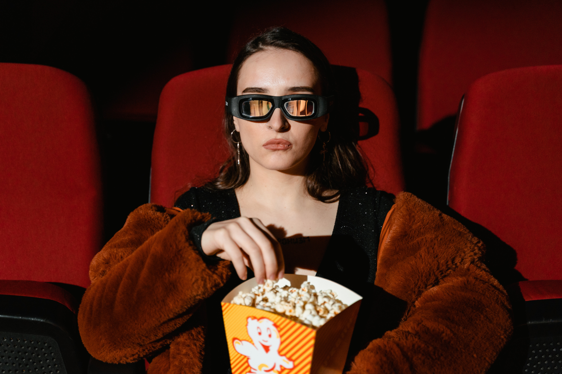 'Woman Watching a Movie Holding a Box of Popcorn' by [Tima Miroshnichenko](https://www.pexels.com/photo/woman-watching-a-movie-holding-a-box-of-popcorn-7991576/).
